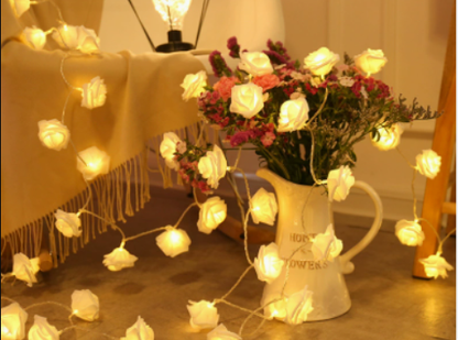 LED Rose Flower String Lights glowing with warm white rose-shaped bulbs decorating a rustic floral arrangement