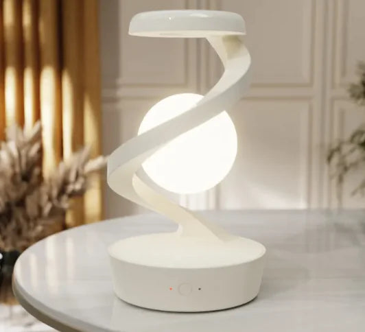 Rotating Moon Desk Lamp with Wireless Charging featuring a glowing moon orb suspended in a curved white frame for ambient light