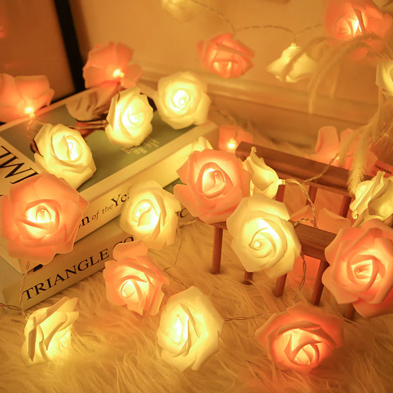 LED Rose Flower String Lights emitting a warm soft glow with white and peach rose-shaped bulbs on a cozy surface