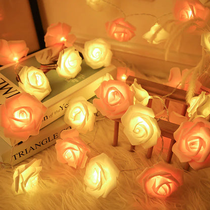 LED Rose Flower String Lights emitting a warm soft glow with white and peach rose-shaped bulbs on a cozy surface