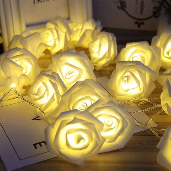 LED Rose Flower String Lights glowing warmly with soft white rose-shaped bulbs arranged on a wooden surface
