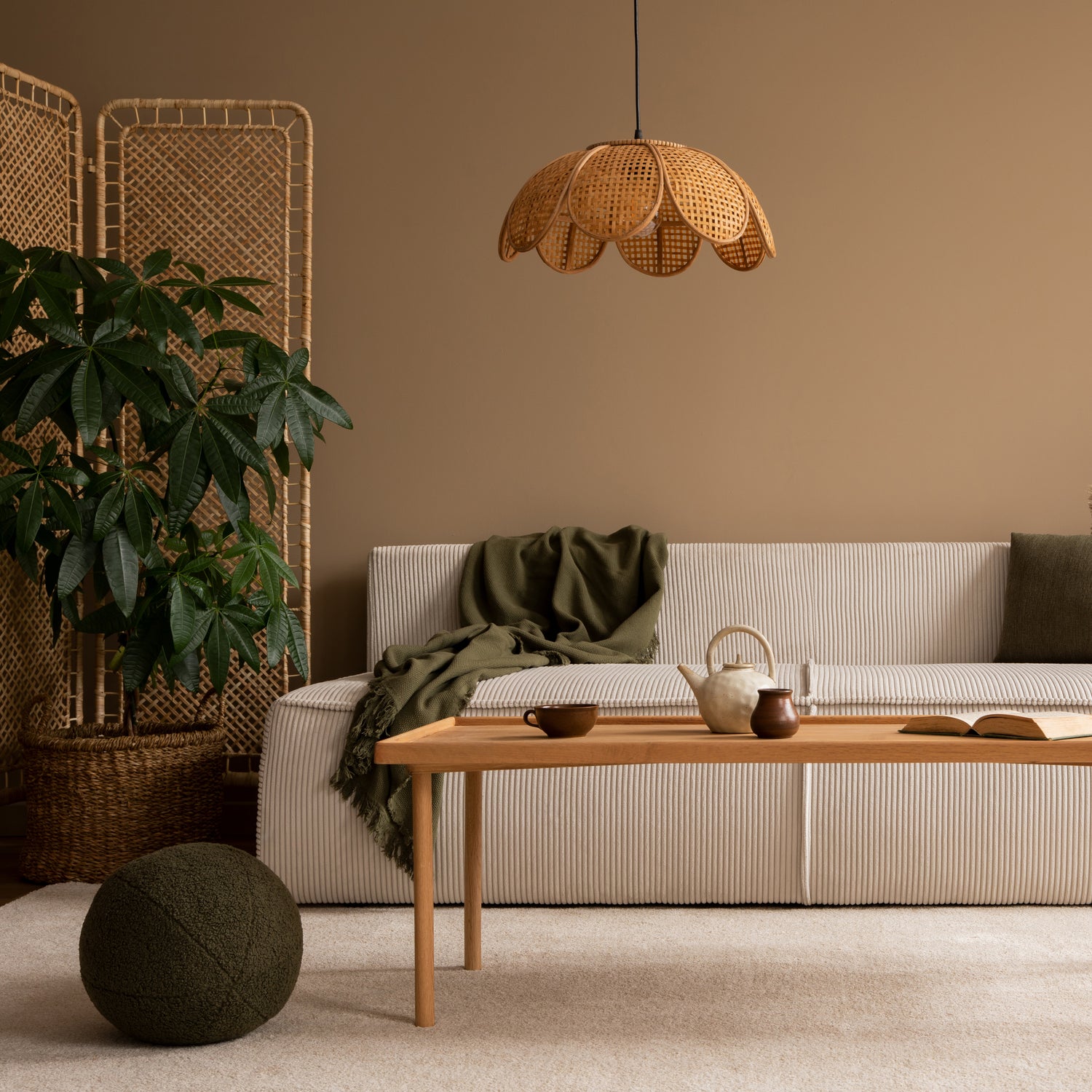 Minimalist living room with striped sofa, wooden coffee table, green throw, potted plant, and rattan pendant light
